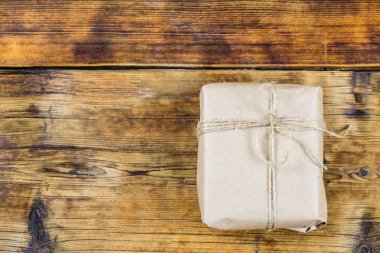 Hediye kraft Kağıt ahşap arka plan üzerinde sarılı. Fotoğraf solda.