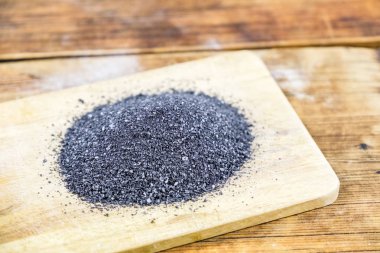 Siyah ahşap tahta üzerinde tuz. Ahşap arka plan. Yakın çekim.