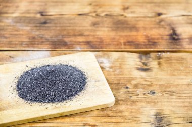 Siyah ahşap tahta üzerinde tuz. Ahşap arka plan. Fotoğraf solda.