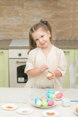 Paskalya yumurta boyamak için küçük kız eğleniyor