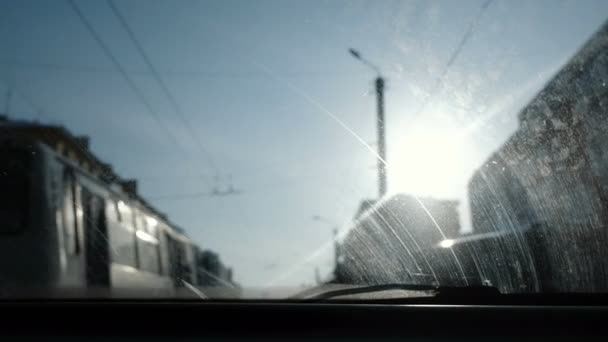 車から街を見る。汚れたフロント ガラスに焦点を当てる. — ストック動画