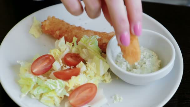 Close-up plate with vegetables and sauce. Female hand dips cheese stick in sauce on a plate. — Stock Video