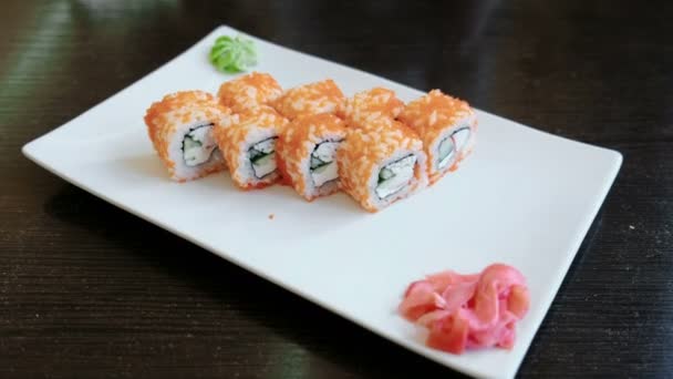 Rollen mit Kaviar mit eingelegtem Ingwer und Wasabi auf weißem rechteckigen Teller. — Stockvideo