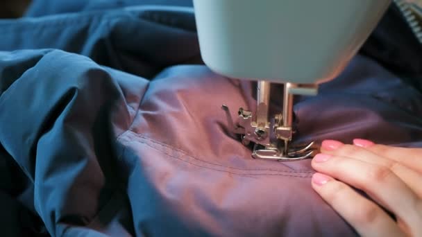 Talors 手のクローズ アップは青のジャケットを縫う縫製機械で革を挿入します. — ストック動画