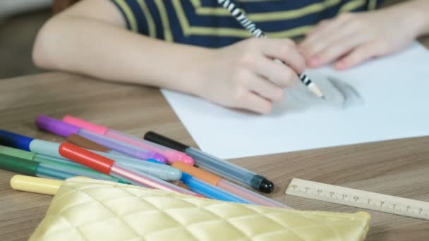 Mãos de crianças close-up são desenhadas com um lápis simples e caneta de feltro em papel branco . — Vídeo de Stock