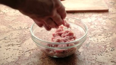 Close-Up eller olun pirzola kıyılmış et mans. Şeffaf plaka mutfak masasının üzerinde.