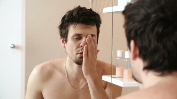 Homme fatigué qui vient de se réveiller en regardant son reflet dans le miroir et voit son apparence battue . — Video