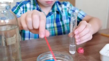 Evde kimya üzerinde deneyler. Sürpriz bir çocuk elinde bir tüp gaz kimyasal reaksiyon ile belgili tanımlık serbest bırakmak. Portre.