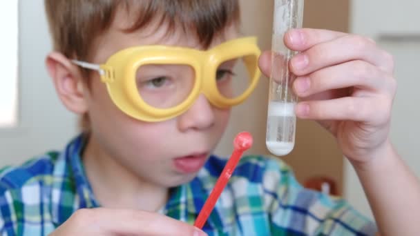 Experimentos de química en casa. Reacción química con la liberación de gas en un tubo de ensayo en las manos de un niño sorprendido . — Vídeos de Stock