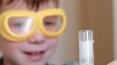 Evde kimya üzerinde deneyler. Kimyasal reaksiyon boy tüp gaz sürümü ile s eller yukarı.