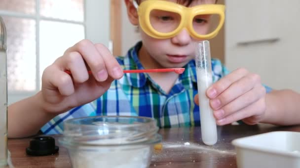 Eksperymenty na chemii w domu. Reakcji chemicznej z uwolnienia gazu w probówce chłopca, s ręce. — Wideo stockowe