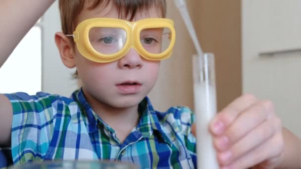 Experimentos de química en casa.Reacción química con la liberación de gas en el tubo de ensayo en las manos del niño. Vierta el agua en el tubo de ensayo utilizando la pipeta . — Vídeos de Stock