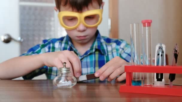 家庭で化学の実験。少年は、マッチで火にアルコール ランプを設定します。. — ストック動画