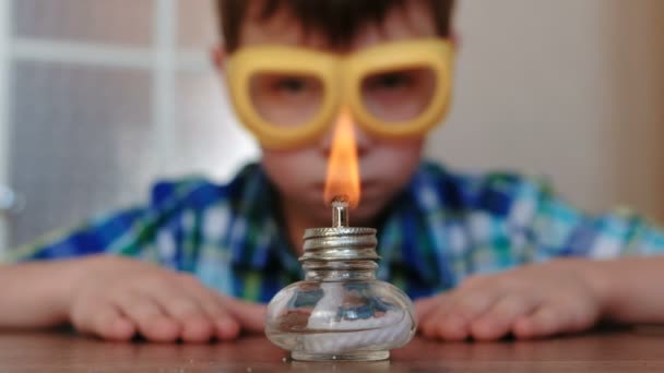 Expériences en chimie à la maison. Garçon regarde la lampe à alcool brûlant . — Video