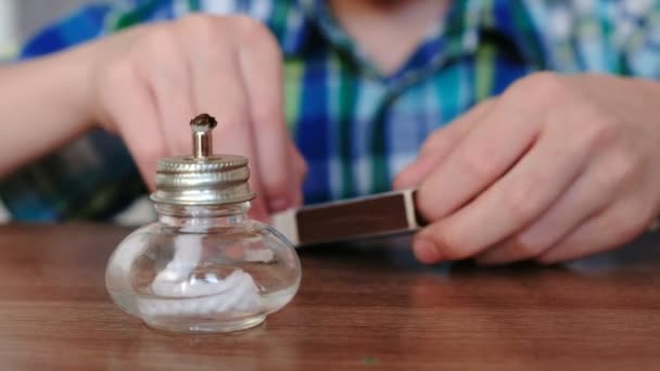 Experimenten op chemie thuis. Closeup jongens handen stelt de brandende alcohol lamp in vuur en vlam met een wedstrijd. — Stockvideo