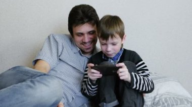 Baba ve oğul birlikte hareket eden telefon içinde oyun oynama.