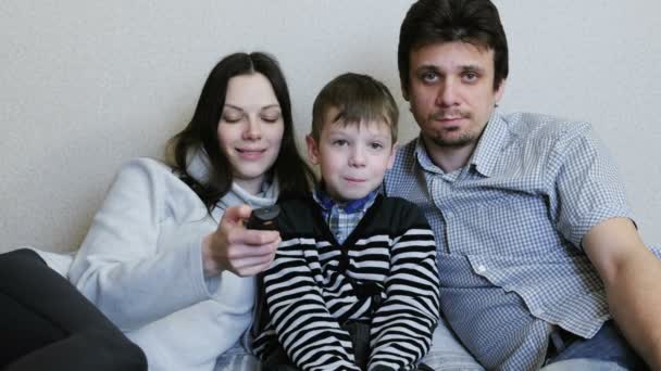 Смотрел телевизор. Молодая семья мама, папа и сын смотрят телевизор вместе . — стоковое видео