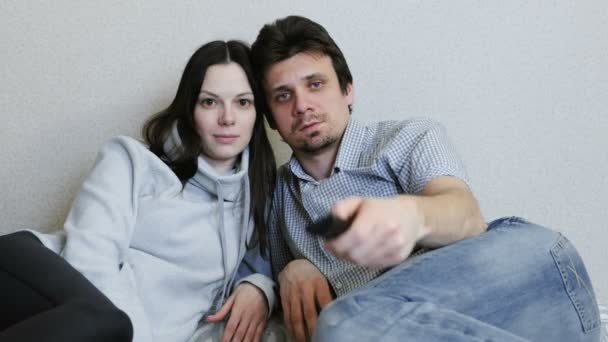 Bored couple watching TV. Man switches channels. — Stock Video