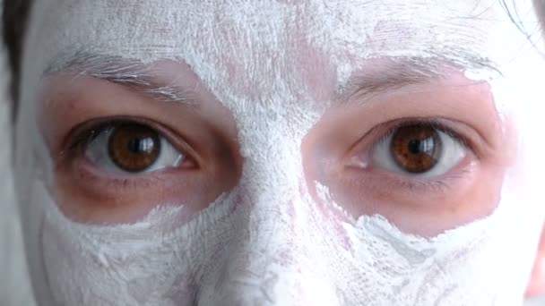 Clay mask on a woman face. Close-up brown eyes. — Stock Video