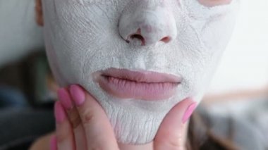 maske bir kadının yüzünde yatıyordu. Yakın çekim dudak ve çene. Maskeyi elini tarafından dokunmadan kadın
