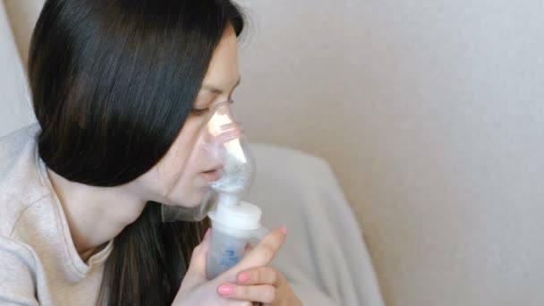 Utilisez un nébuliseur et un inhalateur pour le traitement. Gros plan womans visage inhalant par masque inhalateur. Vue latérale . — Video