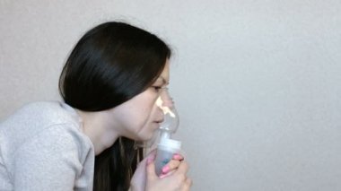 Nebulizatör ve astım tedavisi için kullanın. Genç kadın inhaler maskesi teneffüs edilmesi. Yan görünüm.