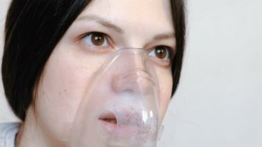 Nebulizatör ve astım tedavisi için kullanın. Closeup kadının yüzü inhaler maskesi teneffüs edilmesi. Önden Görünüm.