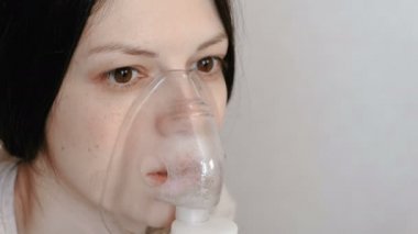 Nebulizatör ve astım tedavisi için kullanın. Closeup kadının yüzü inhaler maskesi teneffüs edilmesi. Önden Görünüm