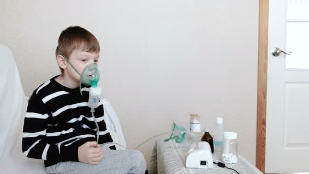 Use nebulizador e inhalador para el tratamiento. Niño inhalando a través de la máscara del inhalador. Vista lateral — Vídeos de Stock