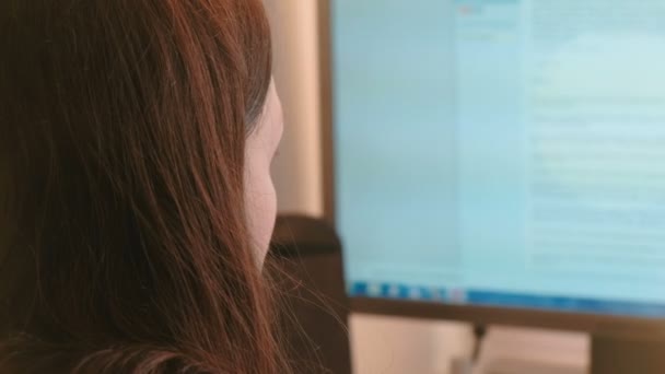 Trabajando en la computadora. Mujer joven irreconocible navegando páginas de Internet en la pantalla. Vista lateral . — Vídeo de stock