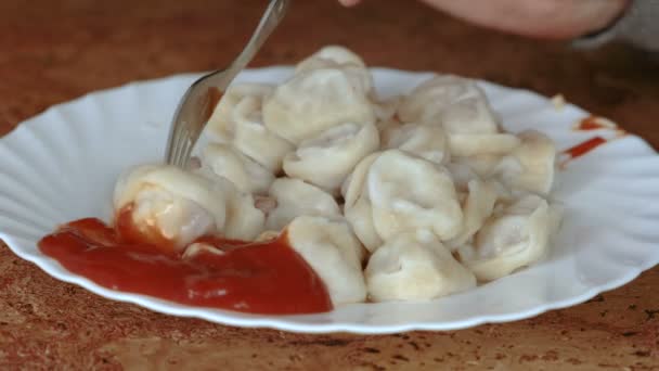 Closeup mans hand eats dumplings with a fork. — Stock Video