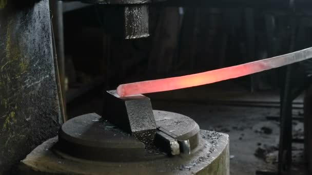 Haciendo la espada de metal en la fragua. Primeros planos mans mano utilizando martillo neumático para dar forma a metal caliente — Vídeos de Stock