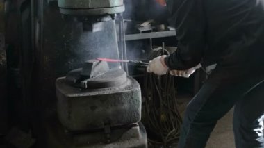 Bıçak dışarı metal demirhane, yapma. Çekiçleri şekil sıcak metal için kullanan adam.