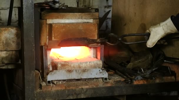 A fazer a faca de metal na forja. Aquecimento de tarugos de metal no forno . — Vídeo de Stock