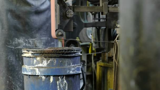 Grinding billets of metal on a belt-grinding machine. Close-up of a mans hand. — Stock Video