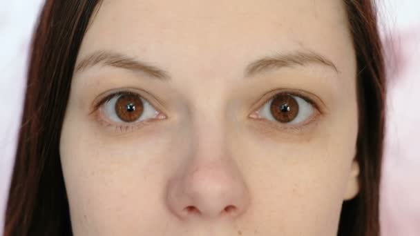 Mladá bruneta žena při pohledu na fotoaparát. Oči a nos detail. — Stock video