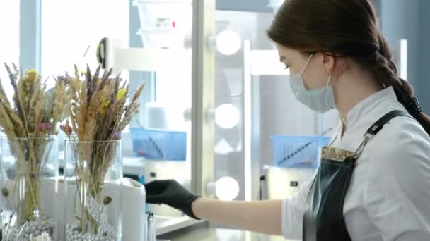 Kosmetikerin ist bereit, in ihrem Kabinett vor dem Spiegel zu arbeiten — Stockvideo