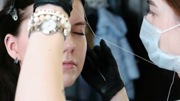 Cosmetologist effectue la procédure de correction du filetage des sourcils. Vue latérale . — Video