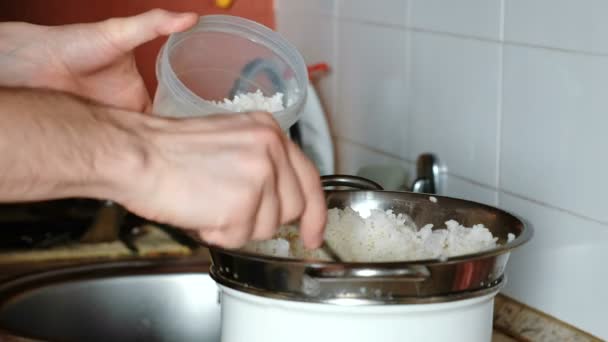 男性の手のクローズ アップがザルのプラスチック容器にご飯を広げ. — ストック動画