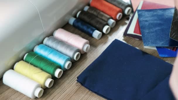 裁缝拿起一根线到织物和皮革在桌子上。背景缝纫机. — 图库视频影像