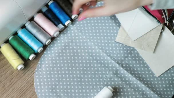 Крупным планом женские руки подбирают цвет нитей к серой ткани в горошек и коже . — стоковое видео