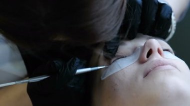 Kozmetik eller istemcileri kirpikleri bir iğne ile paylaşın. Gözlerinin altında pantches ile portre yüz