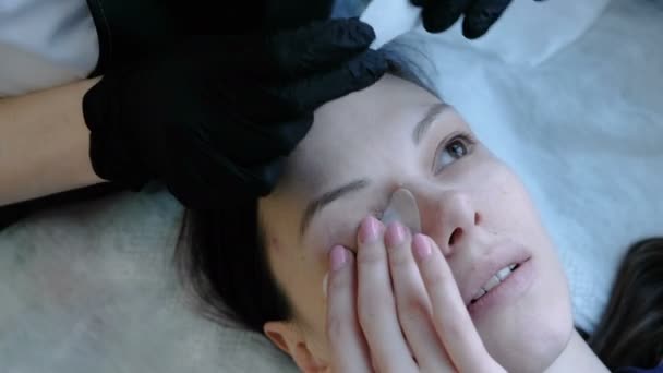 Лікування краси. Косметолог приклеює плями під очима жінки. Вид зверху . — стокове відео