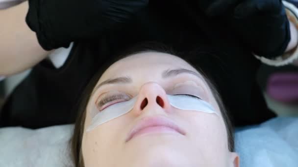 Beauty treatment. Cosmetologist sticks curlers eyelash curler to the eyelids of women. — Stock Video