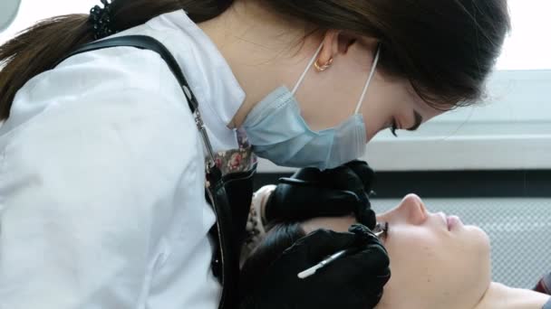 Kosmetolog tar bort ögon papiljotter från ögonfransar med nål. Botox och lash laminering. — Stockvideo