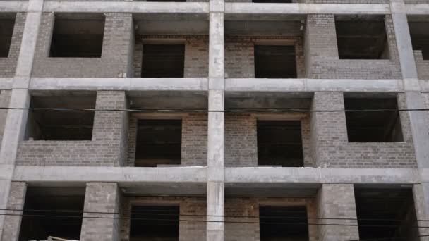 Edifício residencial de vários andares em construção. Vista de perto, câmera se movendo para cima . — Vídeo de Stock