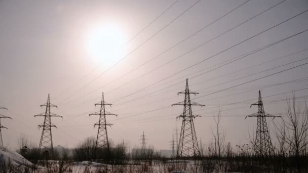 Torres de alto voltaje, línea de transmisión en el fondo de la ciudad de invierno . — Vídeos de Stock