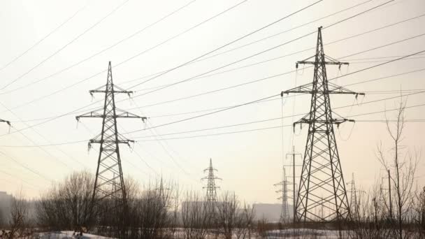 Torres de alto voltaje, línea de transmisión en el fondo de la ciudad de invierno . — Vídeos de Stock