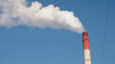 İki kırmızı ve beyaz boru termal güç istasyonunun duman gökyüzü arka plan ile. Sağdan sola hareketli kamera.