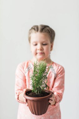 Saksılı bitki tutan şirin çocuk